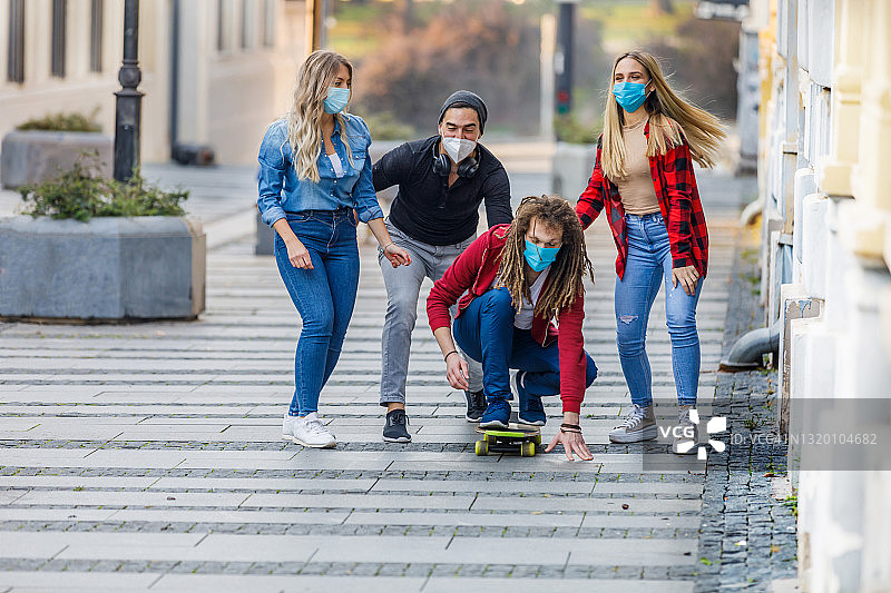 一小群朋友正在城市街道上玩滑板。图片素材
