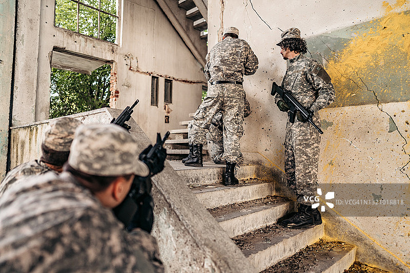 军事突击队在废弃建筑的楼梯上跟踪图片素材