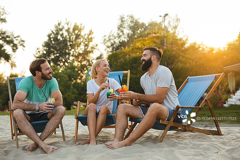 一群朋友喝着鸡尾酒在海滩上放松图片素材