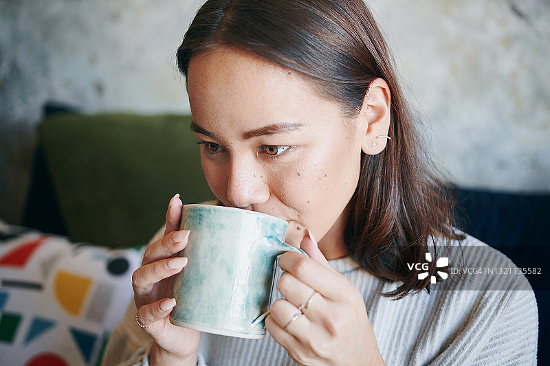 一个年轻女人正在喝咖啡图片素材
