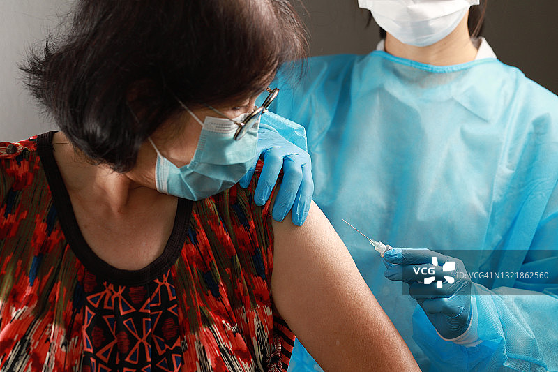 注射器针头和疫苗在护士手中。老年冠状病毒疫苗的研制图片素材