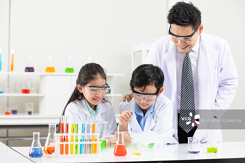 科学老师在实验教室里和学生们一起做化学实验图片素材