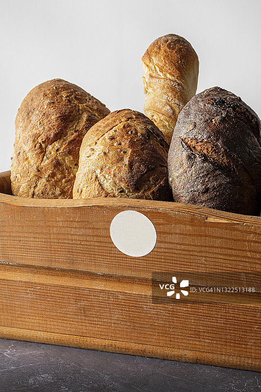 各种各样的烤面包放在木篮子里。图片素材