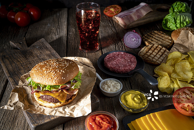 经典的芝士汉堡和薯片和可乐汽水菜单放在质朴的木头桌子上图片素材
