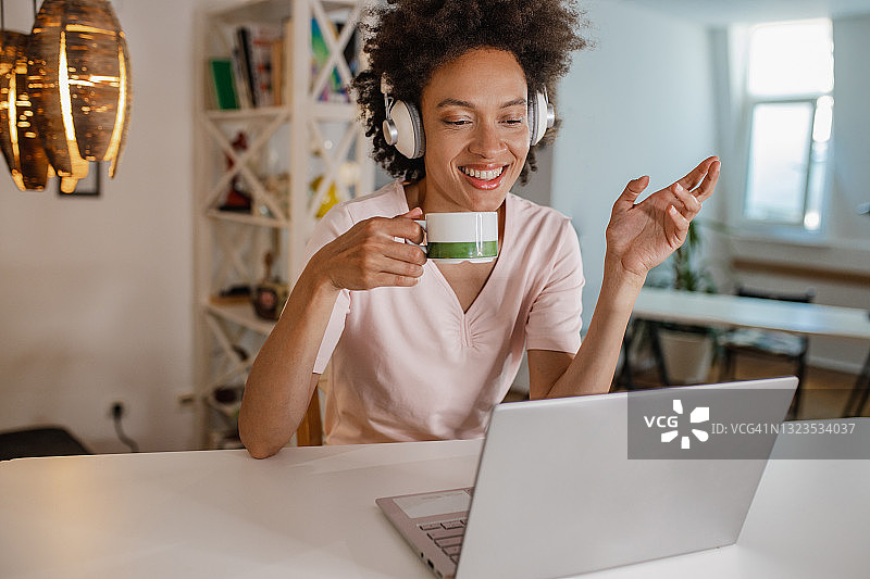 一个女人边喝咖啡边用笔记本电脑工作图片素材
