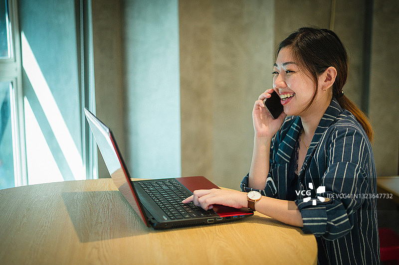 微笑的年轻美丽的亚洲女企业家在笔记本电脑上工作图片素材