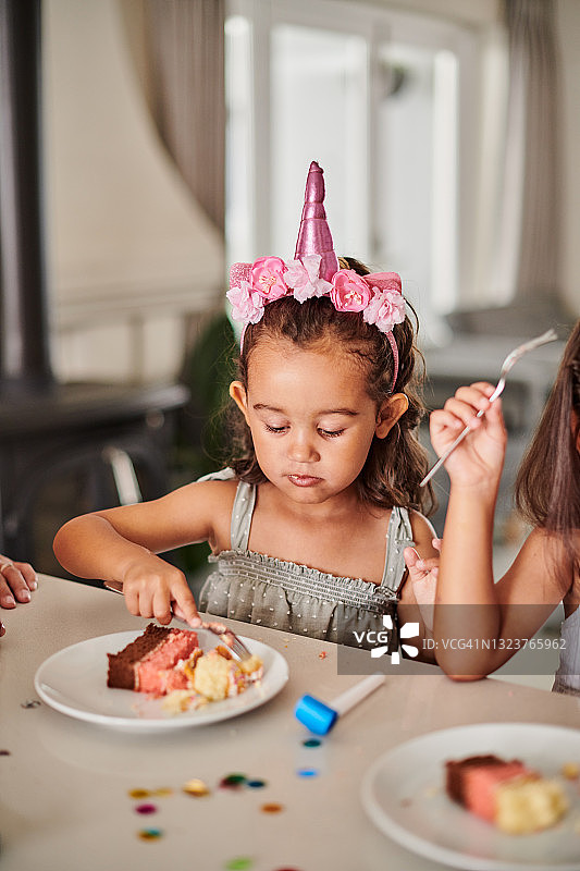 可爱的小女孩在她的生日吃蛋糕的照片图片素材
