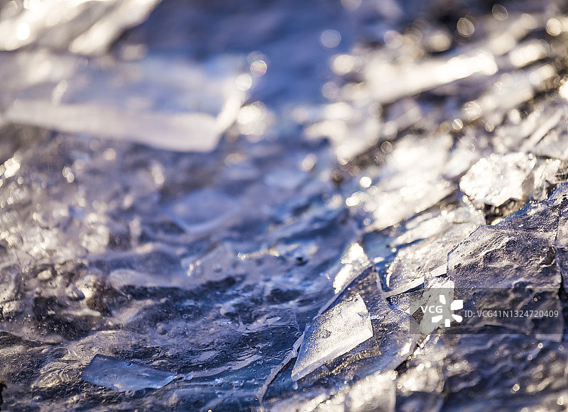 冰冻的湖泊或河流上的冰块的特写。近距离观察碎冰的碎片。湖面上的碎冰。冬天的背景。图片素材