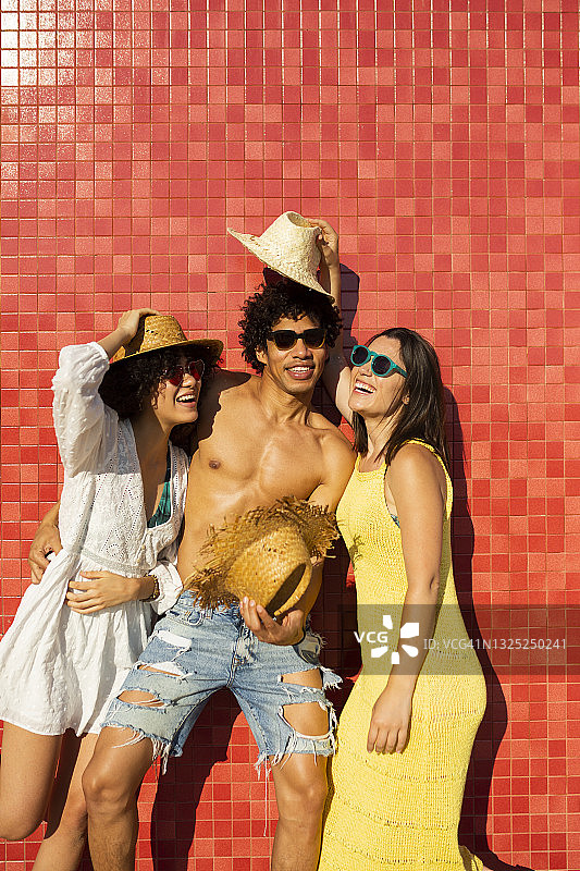三个人在红色背景下玩草帽图片素材