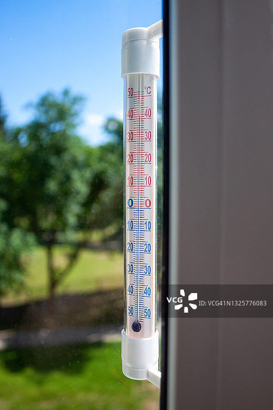窗框上的摄氏温度表显示，在室外异常炎热的情况下，高温高达41.5度。热的概念照片，全球变暖，高温，气候变化图片素材