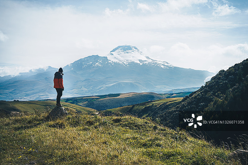 一名男子站在卡扬贝火山前，欣赏美丽的景色图片素材