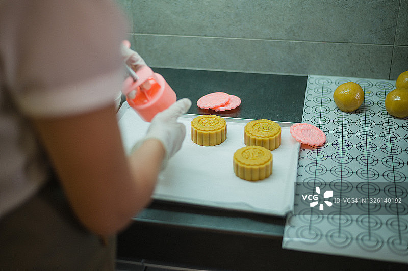在烘烤前的烤盘上，女人们正在制作自制月饼糕点的面团图片素材