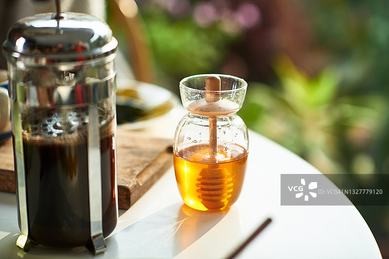 桌子上的咖啡壶和蜂蜜罐的特写图片素材