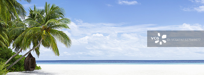 美丽的热带海滩，白色的沙滩，蓝绿色的海洋，晴天的蓝天。一棵棕榈树俯在水面上。暑假在马尔代夫或塞舌尔群岛的背景图片素材