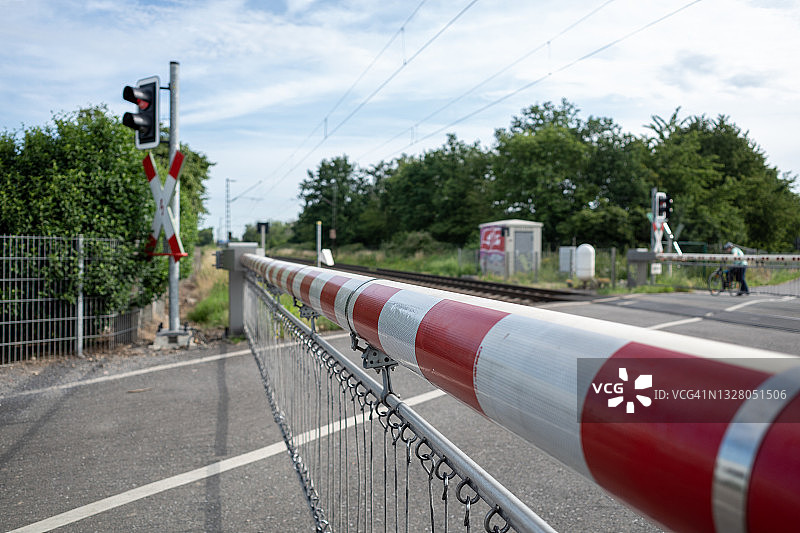 户外阳光和选择性焦点的观点，在红白水平交叉铁路路障路障在德国农村的道路。图片素材