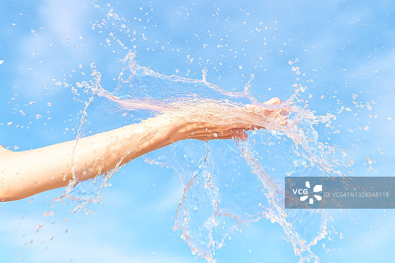 女人用手把水花溅在它的蓝天上图片素材