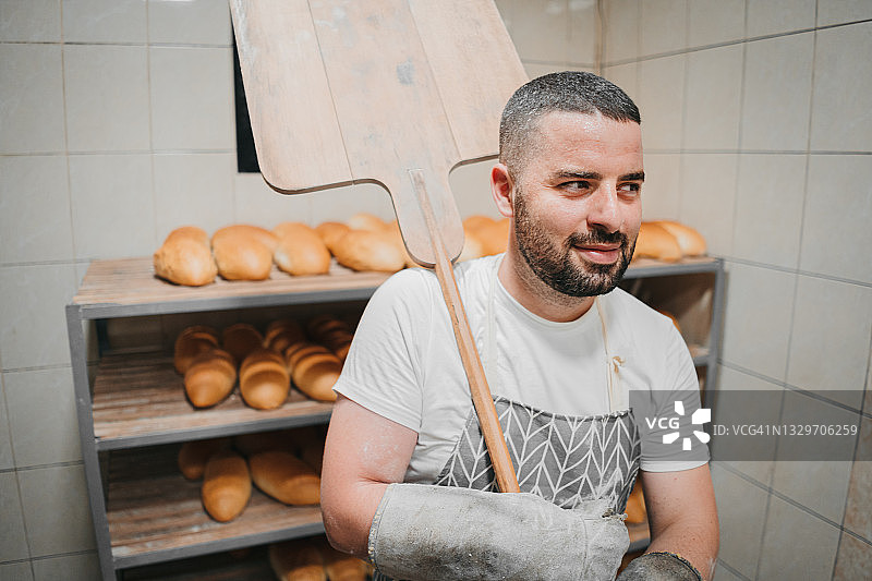 面包师在他的面包房烤面包图片素材