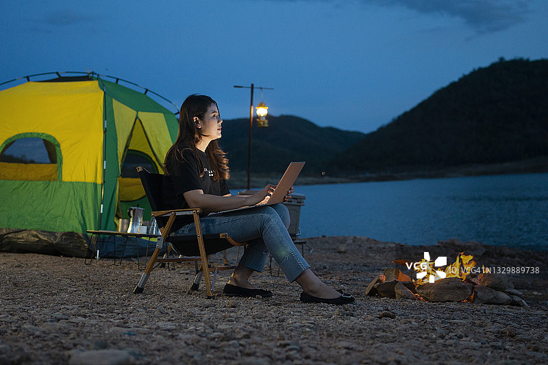 在湖边用笔记本电脑工作的女人图片素材