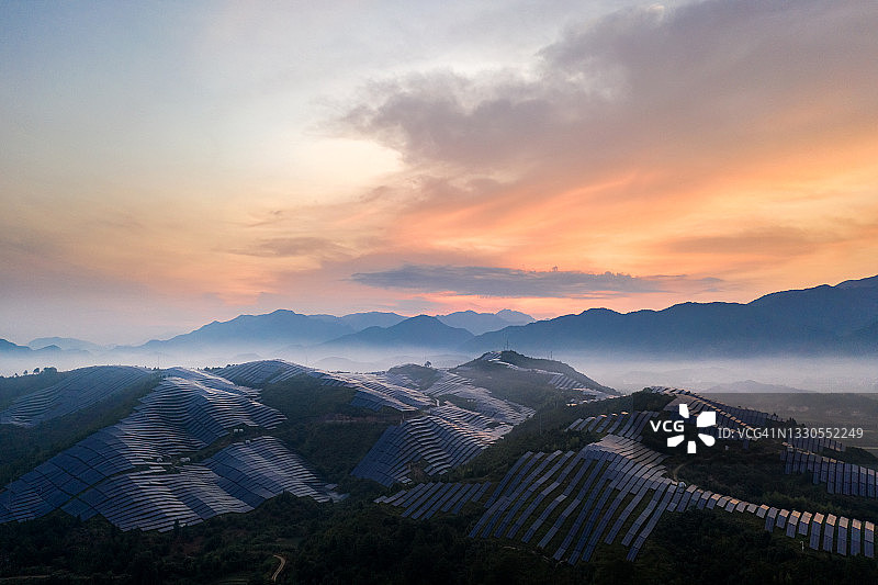 清晨日出时鸟瞰山顶壮丽的太阳能发电站图片素材