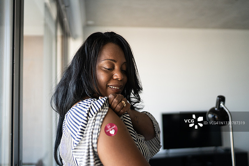 一名成熟女性手臂上贴着“接种过疫苗”的贴纸图片素材