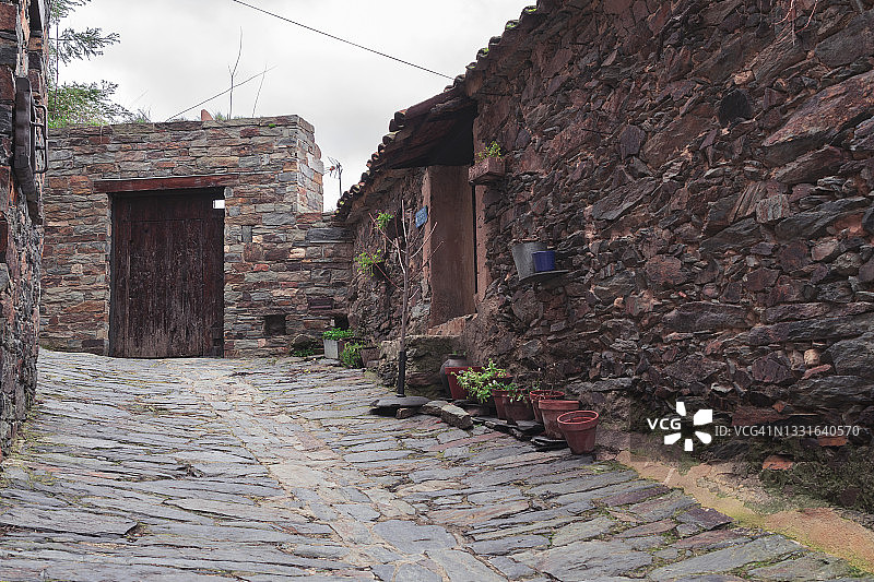 西班牙马德里北部帕内斯村狭窄的鹅卵石街道和古老的石头建筑。图片素材