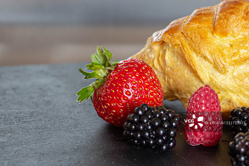 红润的羊角面包配树莓，草莓和黑莓图片素材