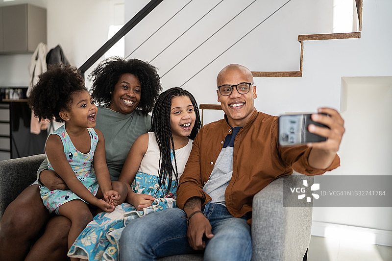 家人在家里用智能手机自拍或打视频电话图片素材
