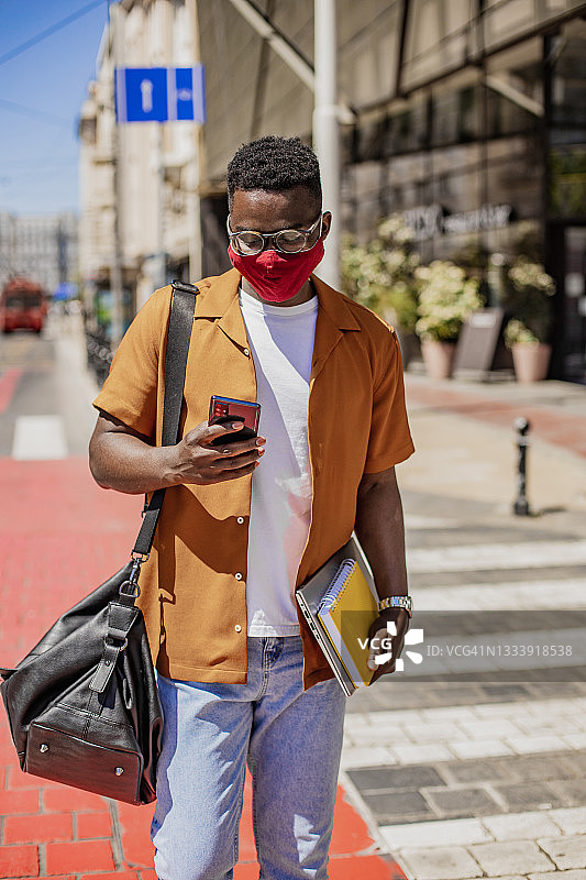 非裔美国年轻人戴着防护口罩走路图片素材