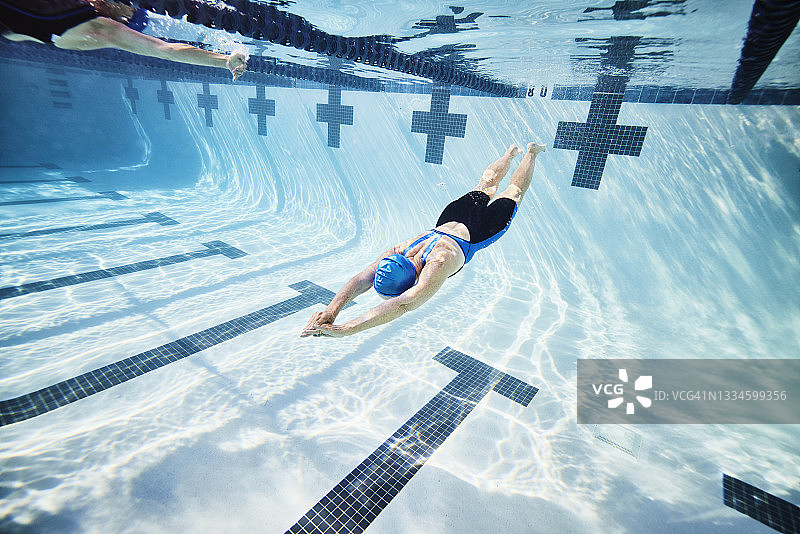 资深女运动员在泳池训练时推墙的宽镜头水下视野图片素材