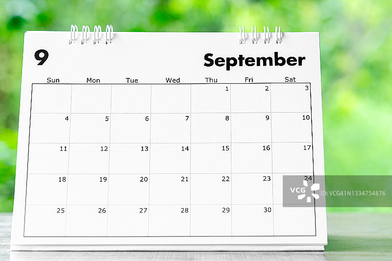 2022年9月日历桌，供主办方在自然背景木桌上规划和提醒。图片素材