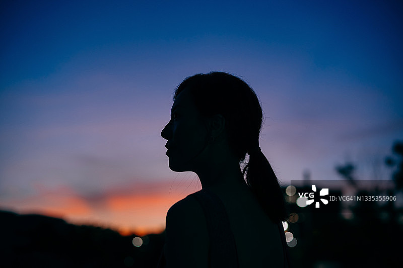年轻的亚洲女人侧面轮廓的剪影俯瞰天空享受大自然中的黄昏。自由的天性。与自然的联系图片素材