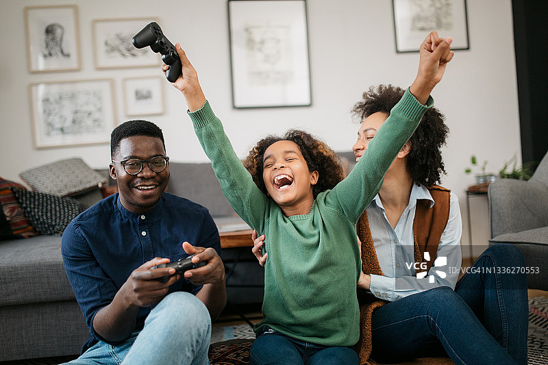 快乐的非裔美国家庭在家里玩电子游戏图片素材