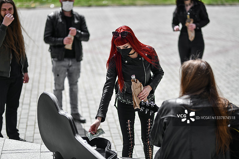 哥特红发女粉丝为街头摇滚歌手捐款图片素材
