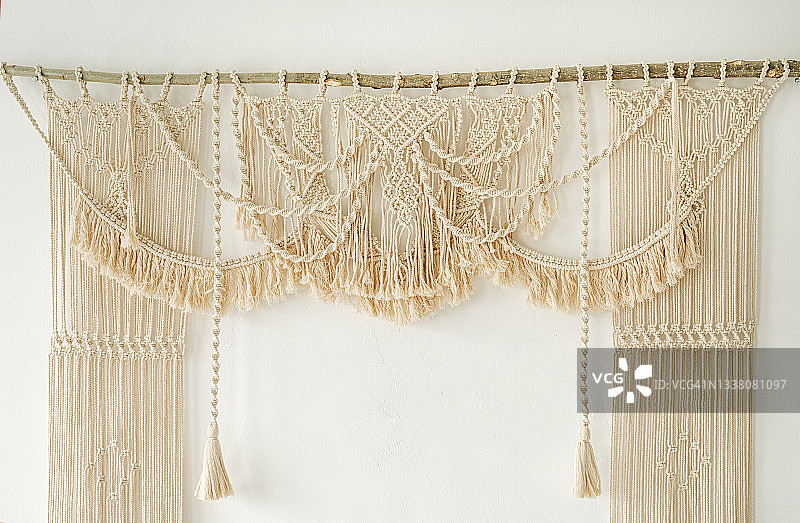 手工编织的流苏婚礼拱门白墙棉编织波西米亚风格图片素材