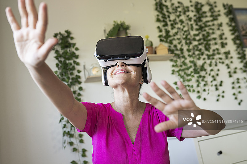 女人在家中通过耳机享受虚拟现实图片素材