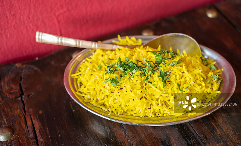 一种印度式的黄米饭，盛在碗里，端上餐桌。图片素材