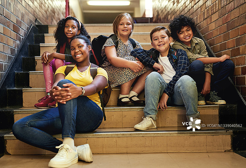 一群不同类型的孩子一起坐在学校的楼梯上图片素材