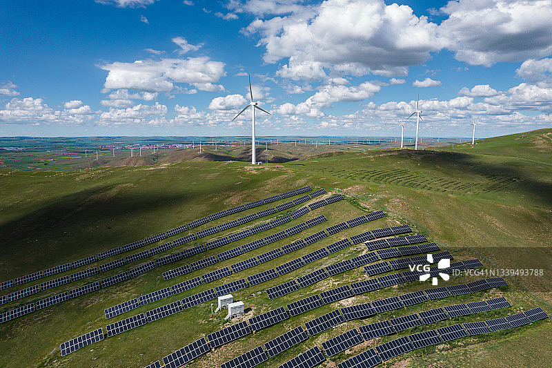 草原上的风力涡轮机和太阳能电池板的无人机视角图片素材