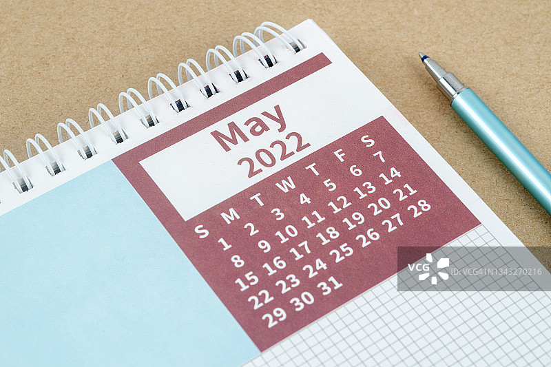 日历桌2022年5月月，顶部视图日历计划和笔在灰纸背景。图片素材