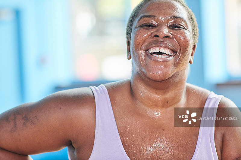 一个女人在健身房笑的特写照片。图片素材