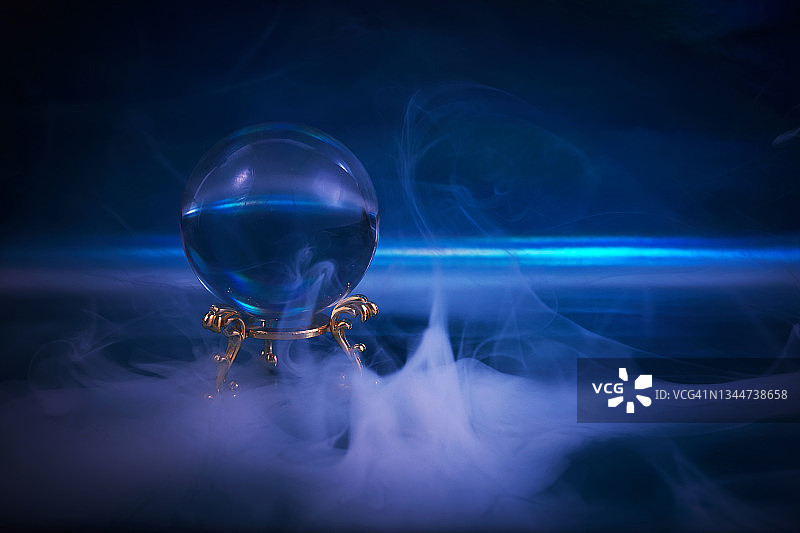深蓝色烟雾背景中的水晶球。猜测未来。图片素材