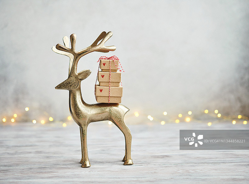 可爱的金鹿携带礼物栈浅灰色的背景为圣诞节图片素材