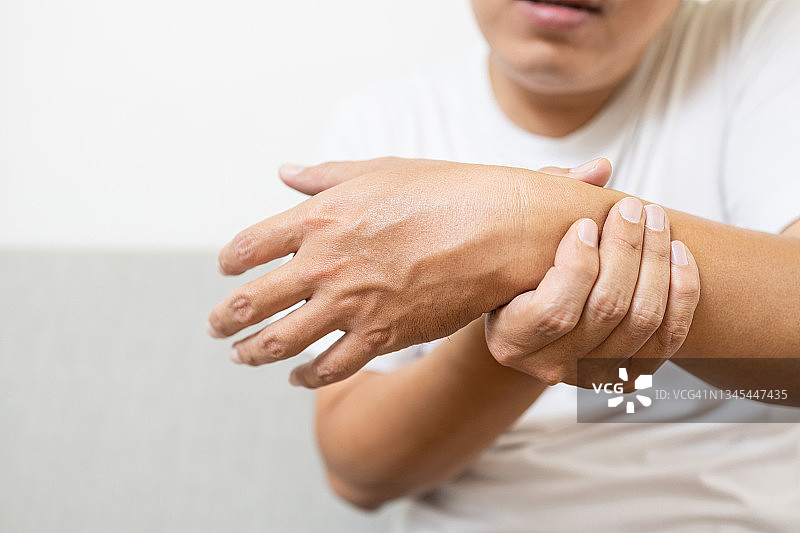 亚洲中年男性患痛风、类风湿性关节炎、慢性关节炎，伴有疼痛，手腕骨损伤，男性患者手、腕痛无力，手脚气或手指麻木图片素材
