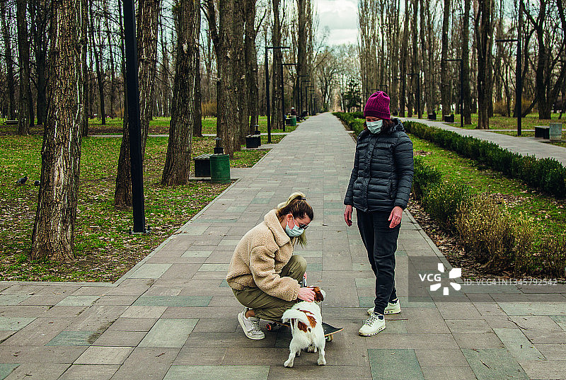 两个女人在公园里和狗玩图片素材