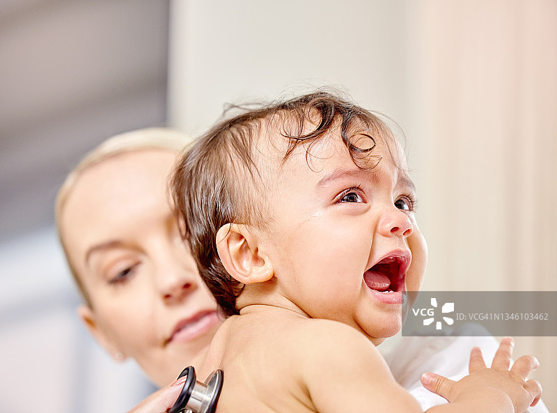 一个婴儿在接受医生检查时哭泣的镜头图片素材