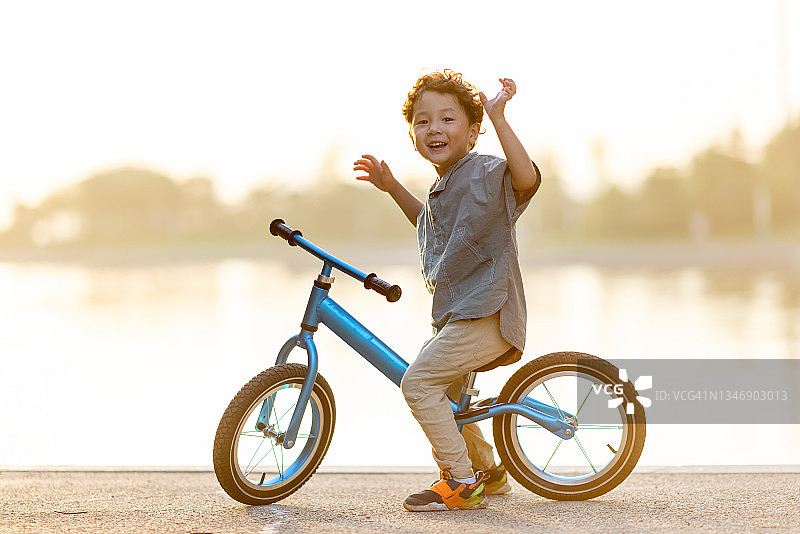 一个小男孩骑着自行车图片素材