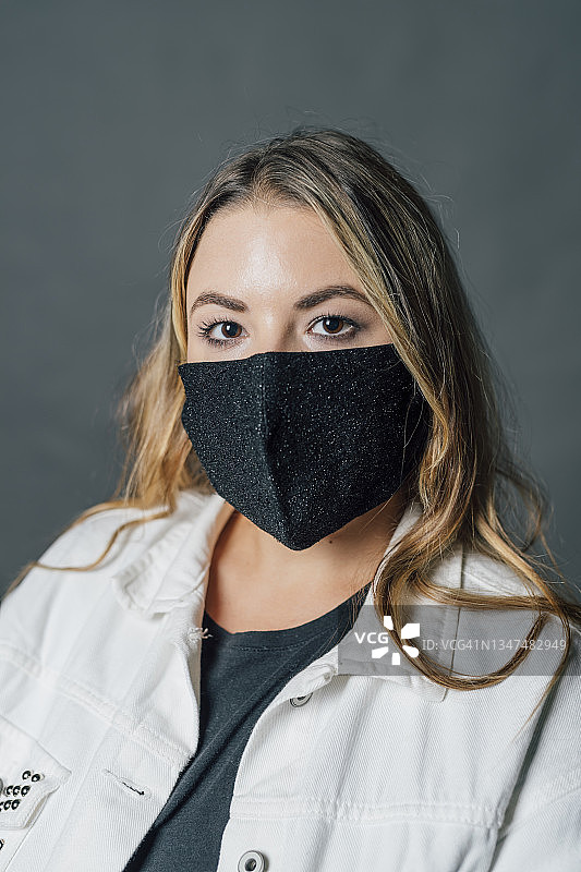 年轻女性在COVID-19期间戴着防护口罩图片素材