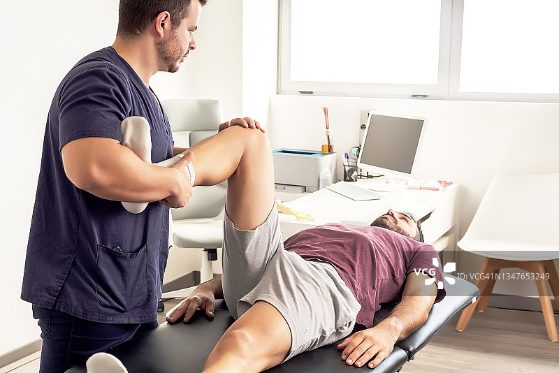 对病人的腿进行活动练习的物理治疗师图片素材