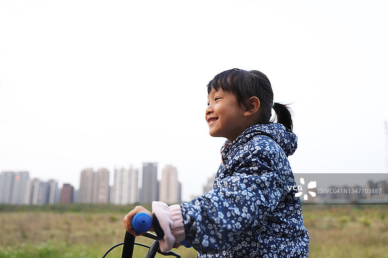 一个女孩在小路上骑自行车。图片素材