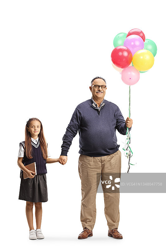 祖父的全身肖像，拿着气球和一个女学生手牵着手图片素材